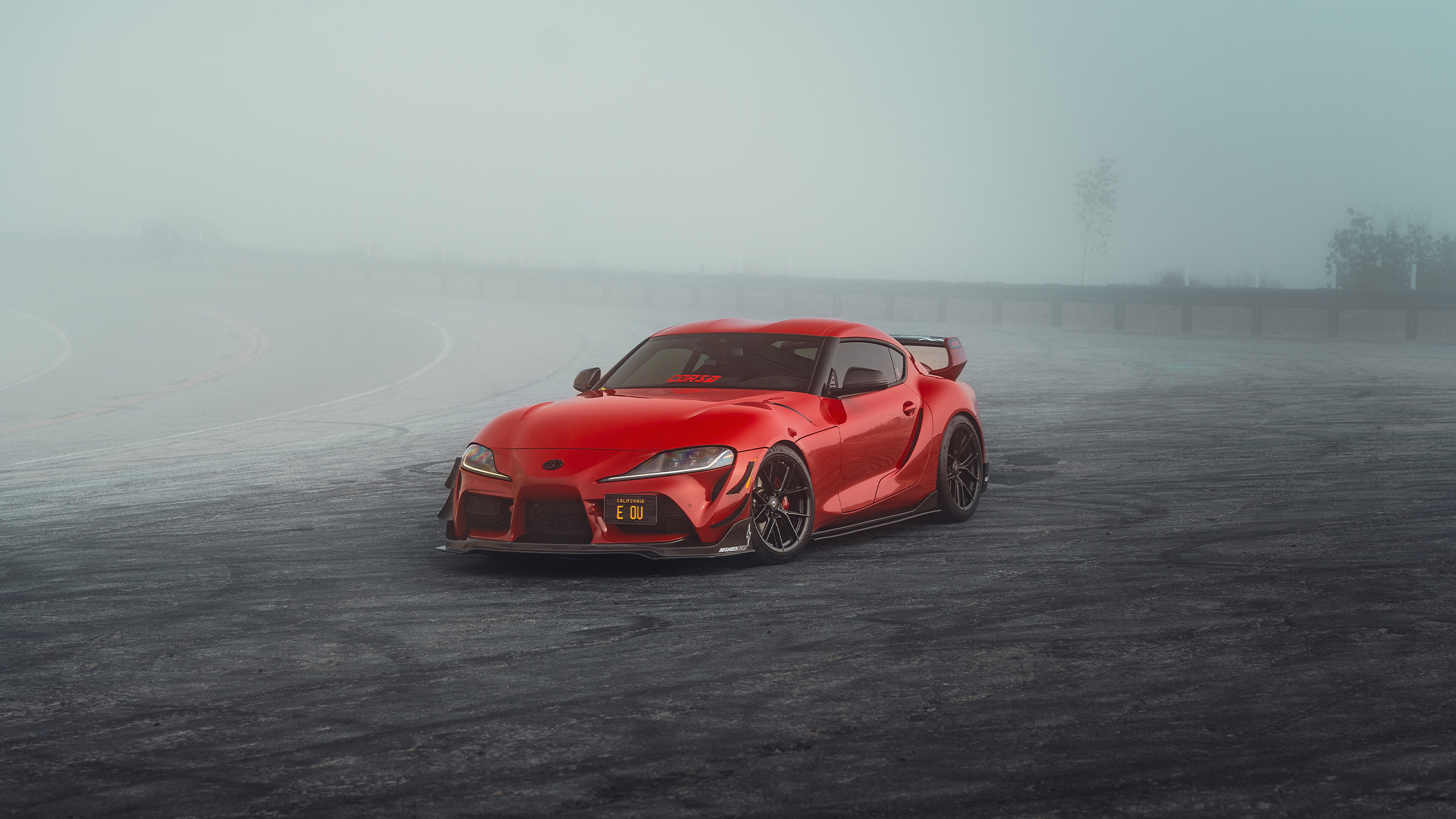 red toyota gr supra on foggy mountain road