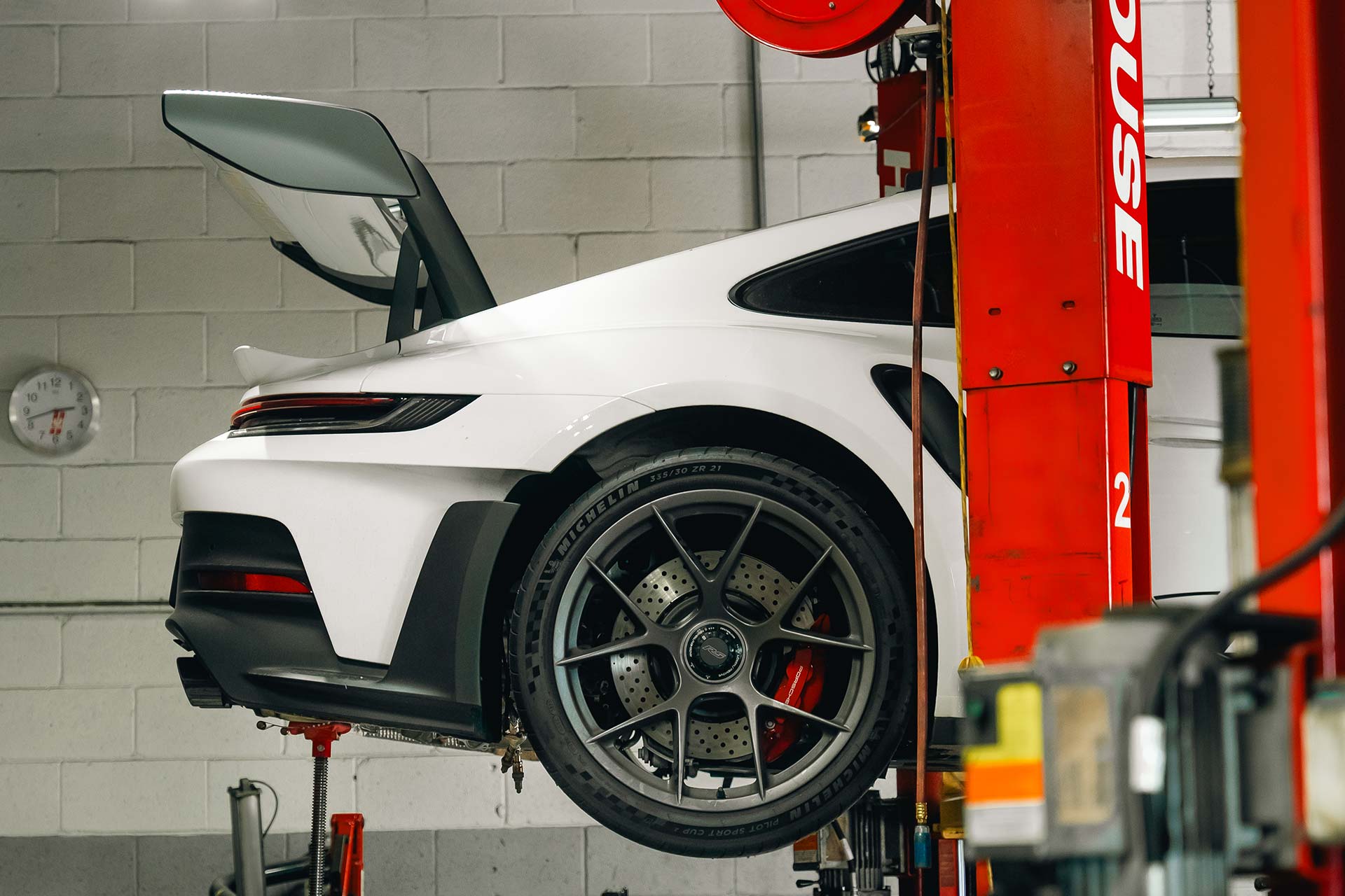 white porsche 911 gt3 rs on the lift at house auto