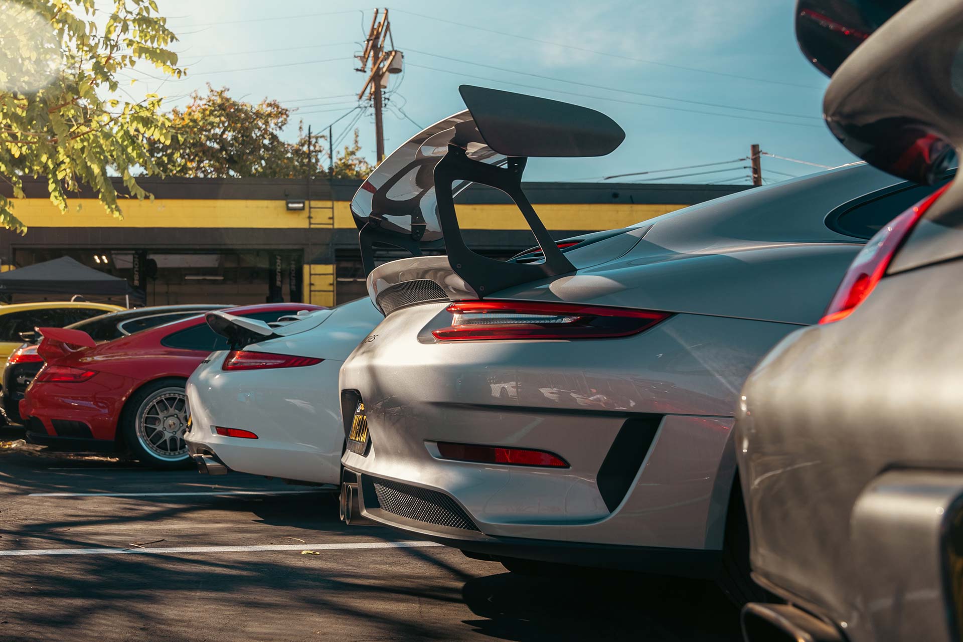 porsche 911s lined up at house automotive in encino