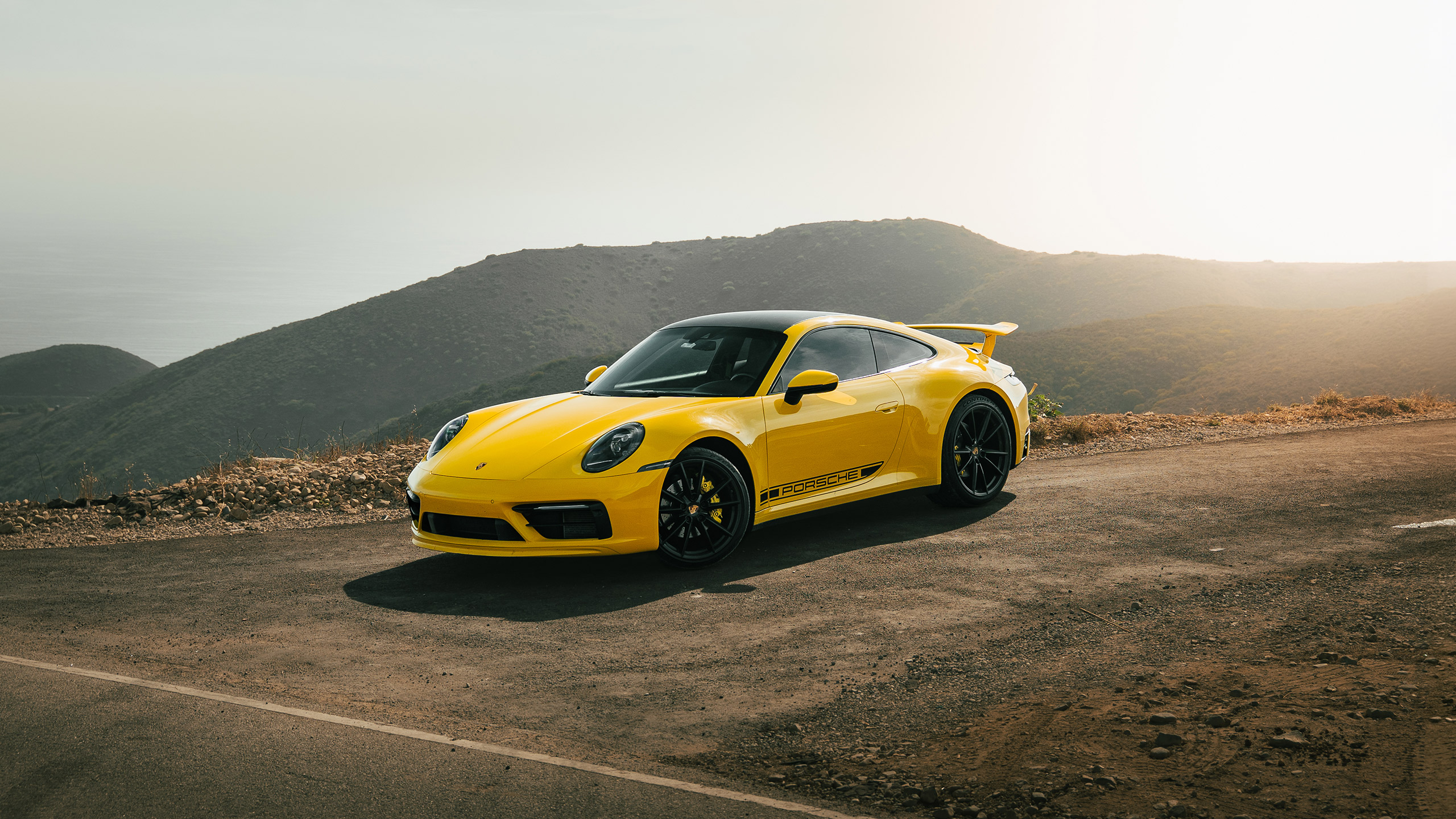 speed yellow 992.2 porsche 911 on beachside canyon top